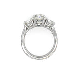 A platinum diamond ring featuring a central round diamond flanked by two round diamonds on a clean white background.