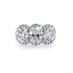 A platinum band ring with three diamond halo settings.