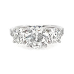 A three-stone diamond ring featuring a round center diamond flanked by two round side diamonds on a polished platinum band, set against a plain white background.