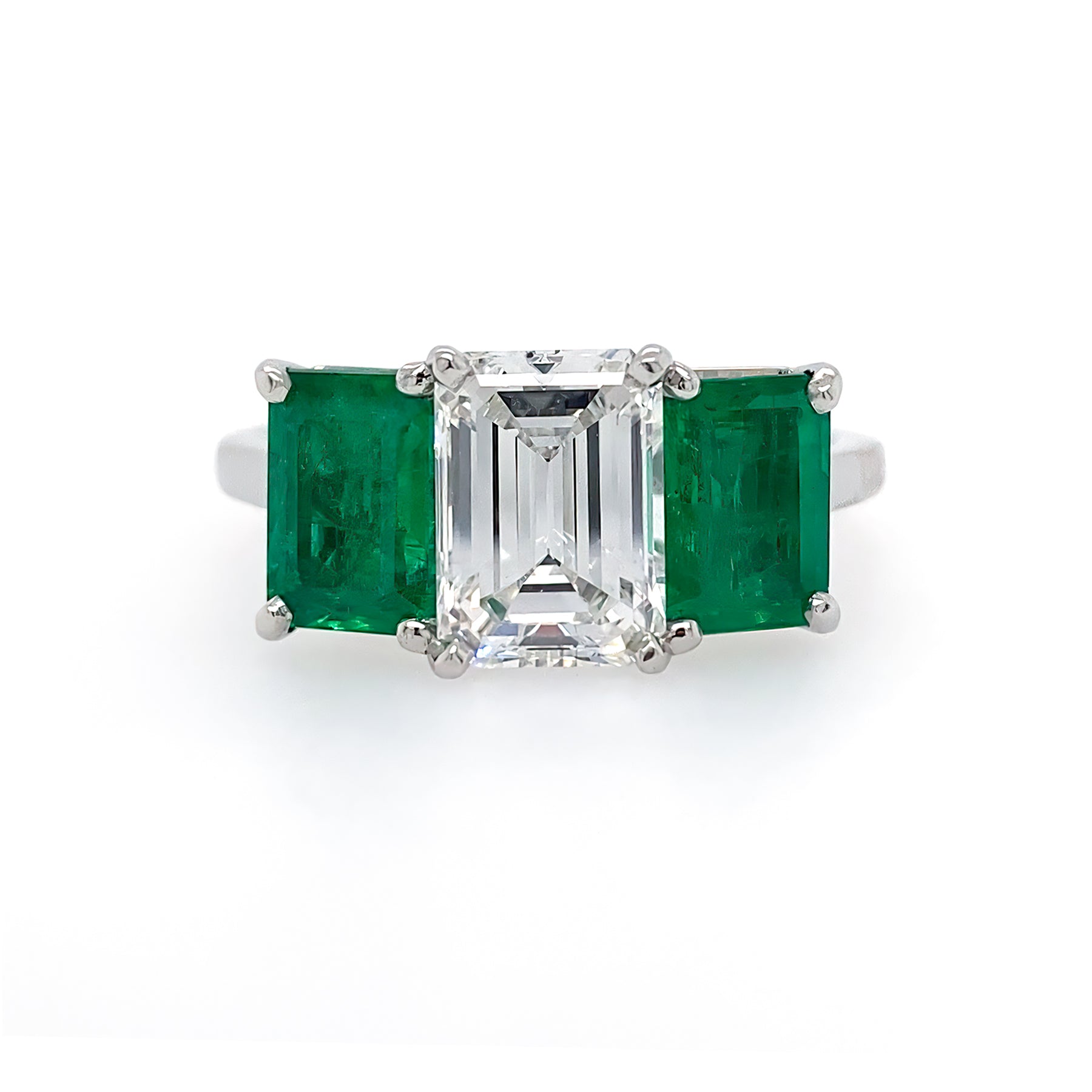 Custom designed Platinum ring with and Emerald cut diamond flanked by two emerald cut emeralds
