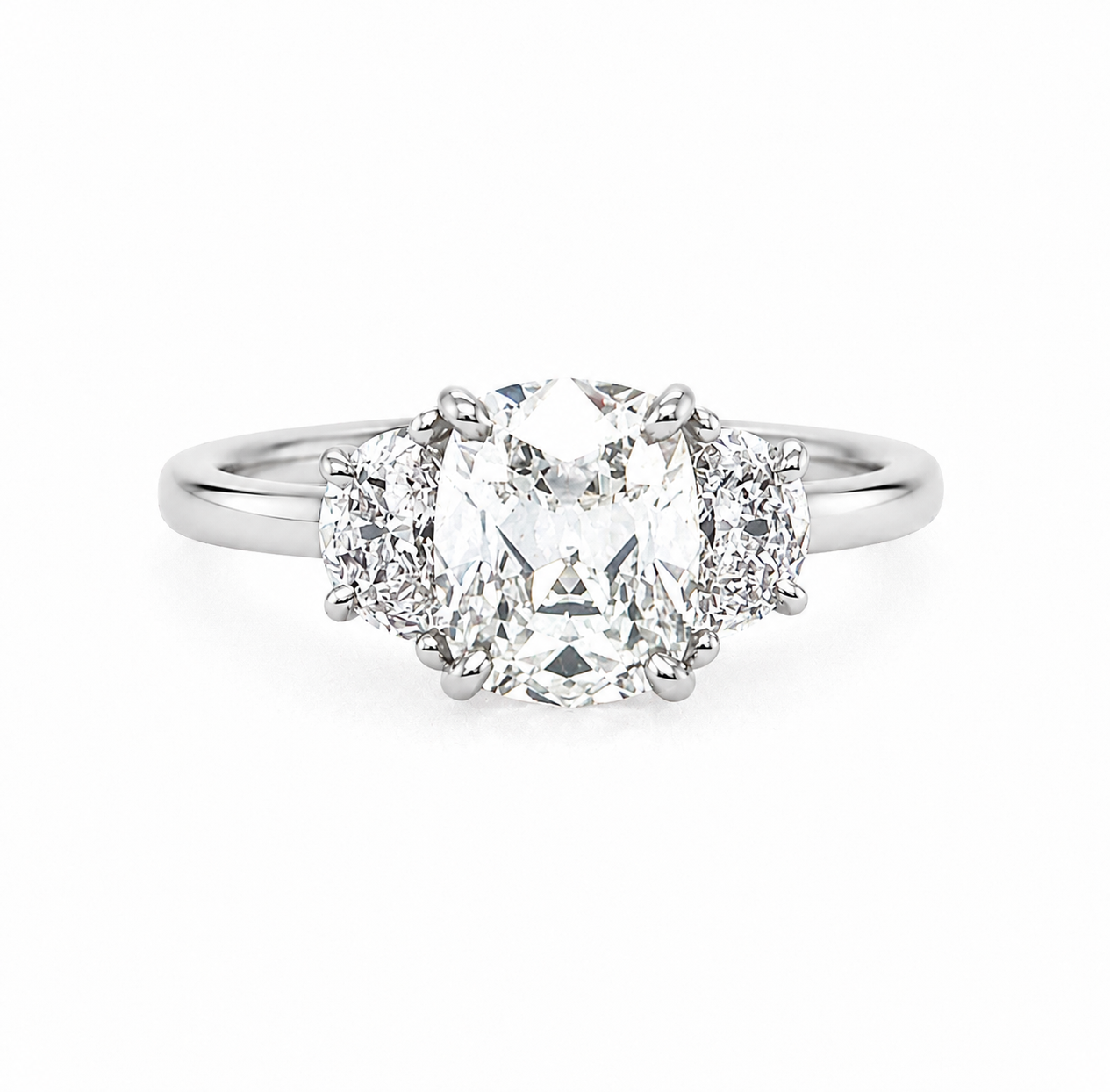 A three-stone diamond ring featuring a large Old Mine center diamond flanked by two smaller half moon diamonds on a polished platinum band, set against a plain white background.