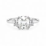 A three-stone diamond ring featuring a large Old Mine center diamond flanked by two smaller half moon diamonds on a polished platinum band, set against a plain white background.