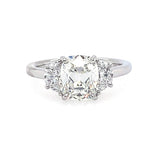 A three-stone diamond engagement ring featuring a central old-mine-cut diamond flanked by two half-moon diamonds on a polished platinum band, set against a plain white background.