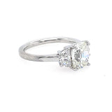 A platinum diamond ring featuring a large old-mine-cut center stone and two smaller half-moon side stones, set on a plain white background.