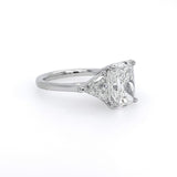 A classic diamond engagement ring featuring a rectangular cushion-cut center stone in a platinum setting on a plain white background.