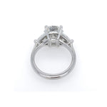 A platinum diamond ring with a large cushion cut center diamond and trillion side stones, shown from a top-down view on a white background.