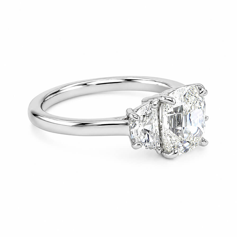 A three-stone diamond ring featuring a central Old Mine cut diamond flanked by two half moon cut diamonds on a polished platinum band, set against a clean white background.