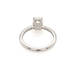 A platinum diamond ring shown from the side, featuring an oval-cut diamond in a four-prong setting with a diamond-accented band, photographed on a solid white background.