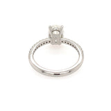 A platinum diamond ring shown from the side, featuring an oval-cut diamond in a four-prong setting with a diamond-accented band, photographed on a solid white background.