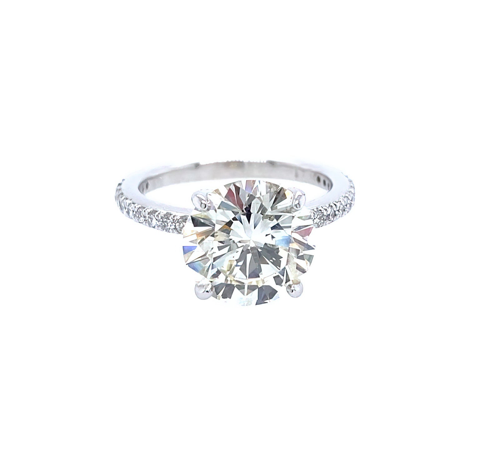 A classic solitaire engagement ring featuring a round brilliant-cut diamond set in a platinum metal band with a prong-set diamonds around the band