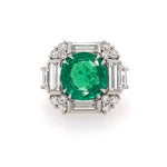 front view of platinum ring with a green emerald and diamonds