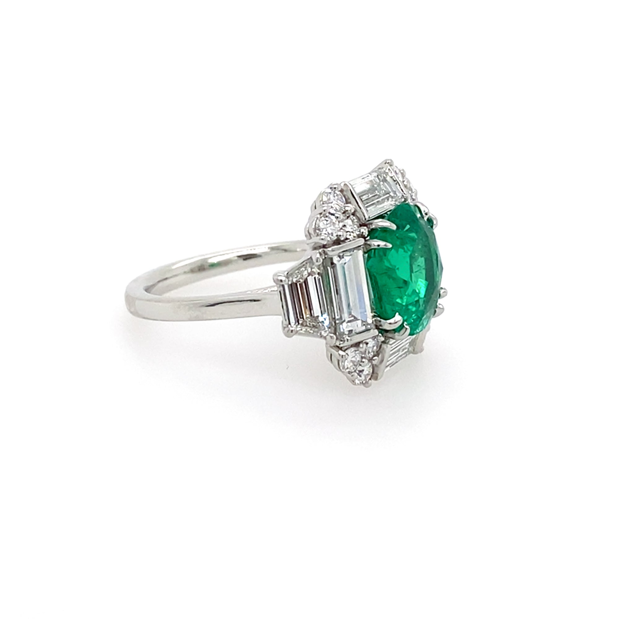 side view of platinum ring with a green emerald and diamonds
