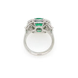 back view of platinum ring with a green emerald and diamonds