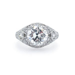 A custom designed platinum band ring with a central diamond and smaller diamonds set around it.