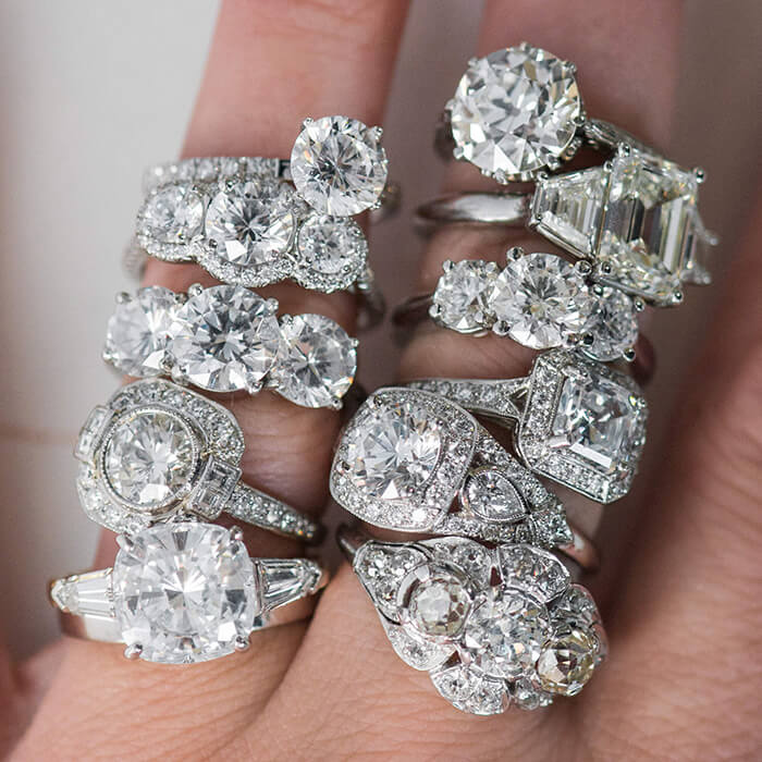 Collection of custom designed diamond engagement rings on a woman's hand