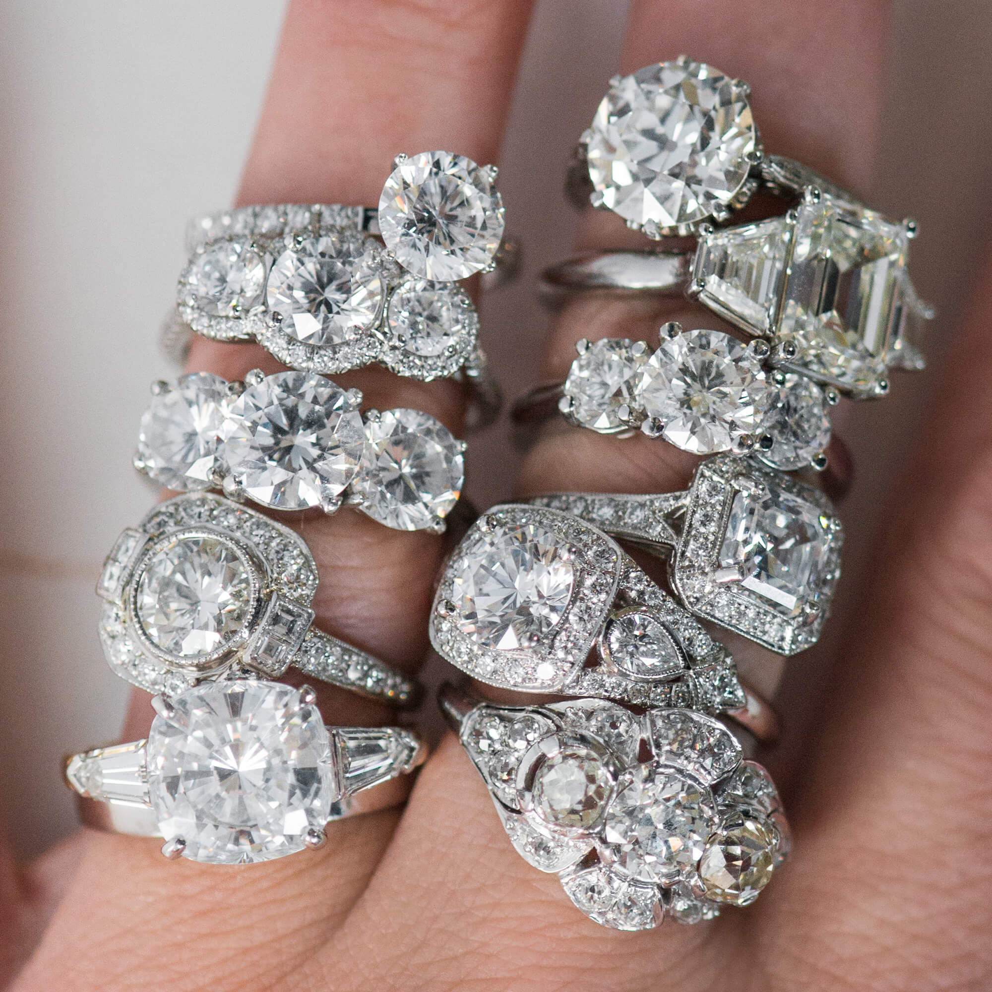 Collection of diamond engagement rings custom-designed by Laura Pearce on a woman's hand