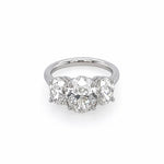 A custom designed three-stone diamond ring featuring a large oval center diamond flanked by two oval side diamonds, set in a polished platinum band against a plain white background.