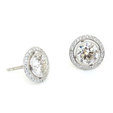 Pair of custom designed platinum earrings with diamonds 
on a white background