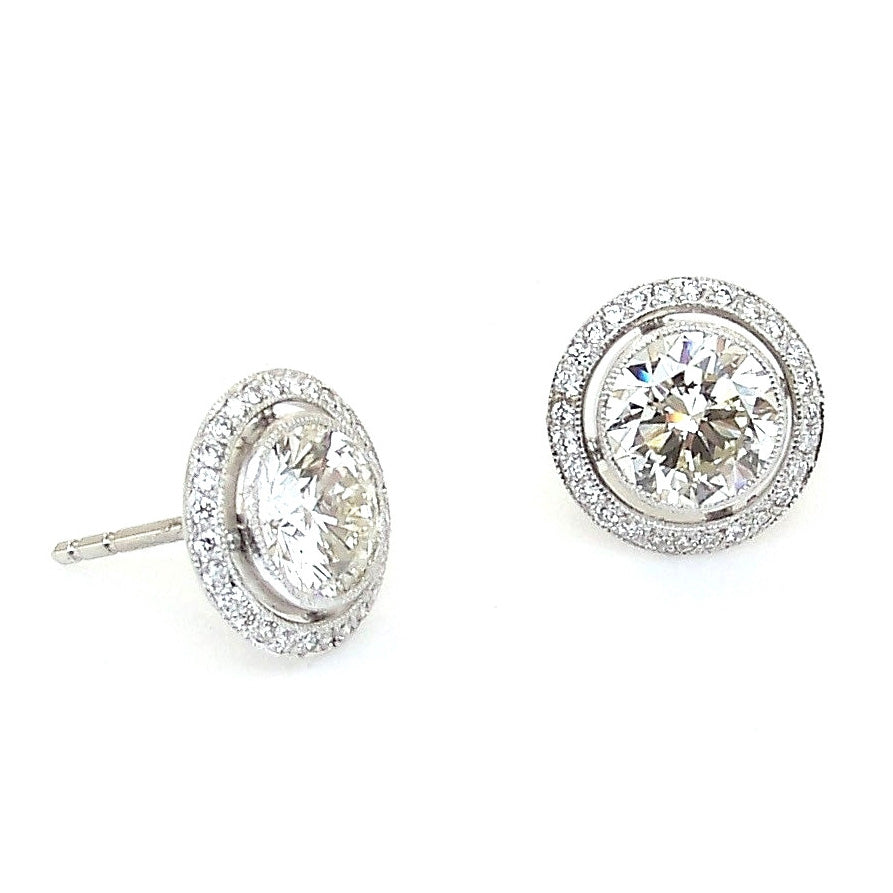 Pair of custom designed platinum earrings with diamonds 
on a white background