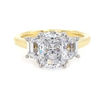 18K yellow gold ring with cushion cut center diamond and smaller trapezoid diamonds on the sides against a white background