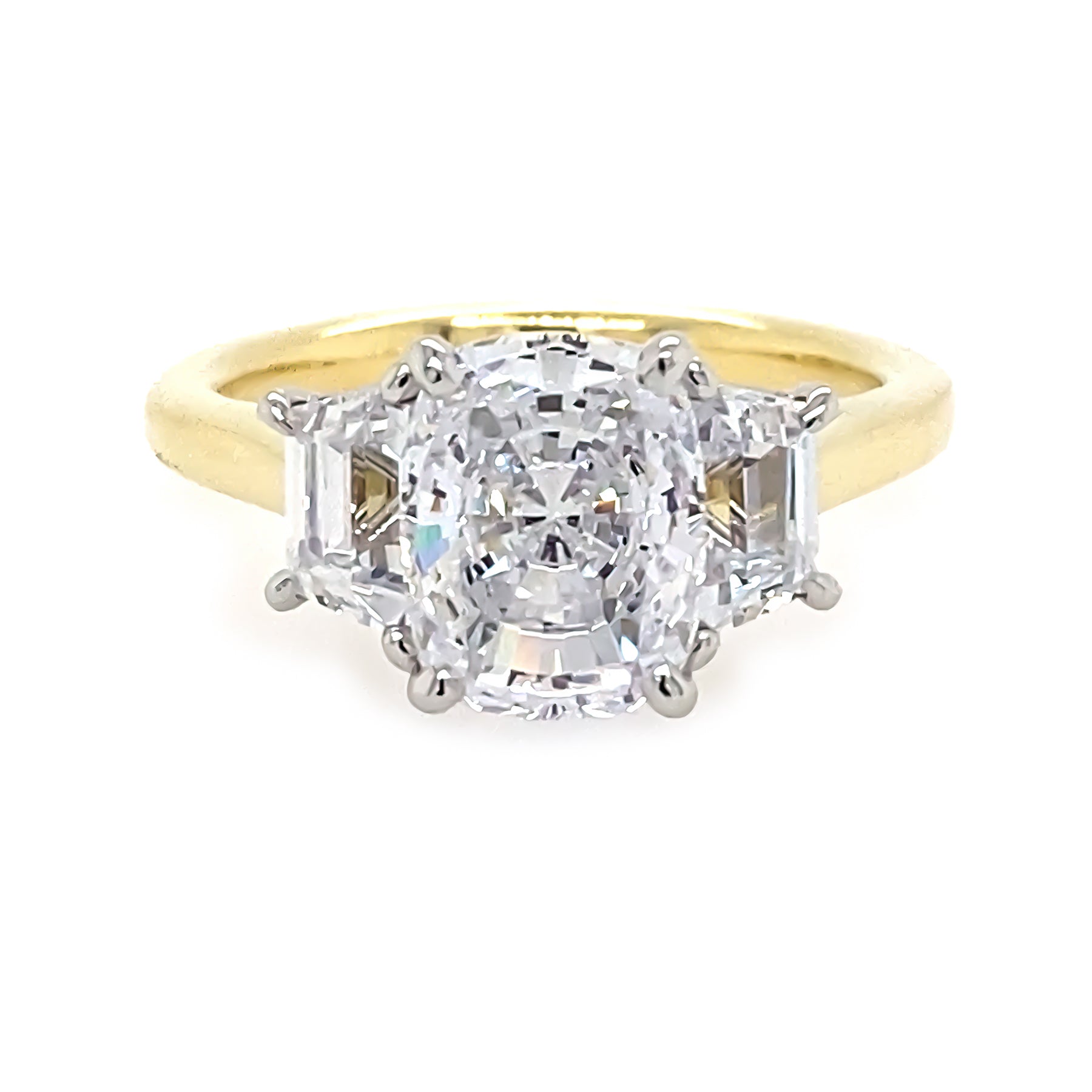18K yellow gold ring with cushion cut center diamond and smaller trapezoid diamonds on the sides against a white background