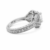 An ornate platinum diamond ring with a filigree band and an Asscher-cut center stone, shown from a side angle on a white background.
