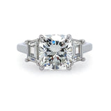 A platinum cushion cut diamond ring with side trapezoid diamonds