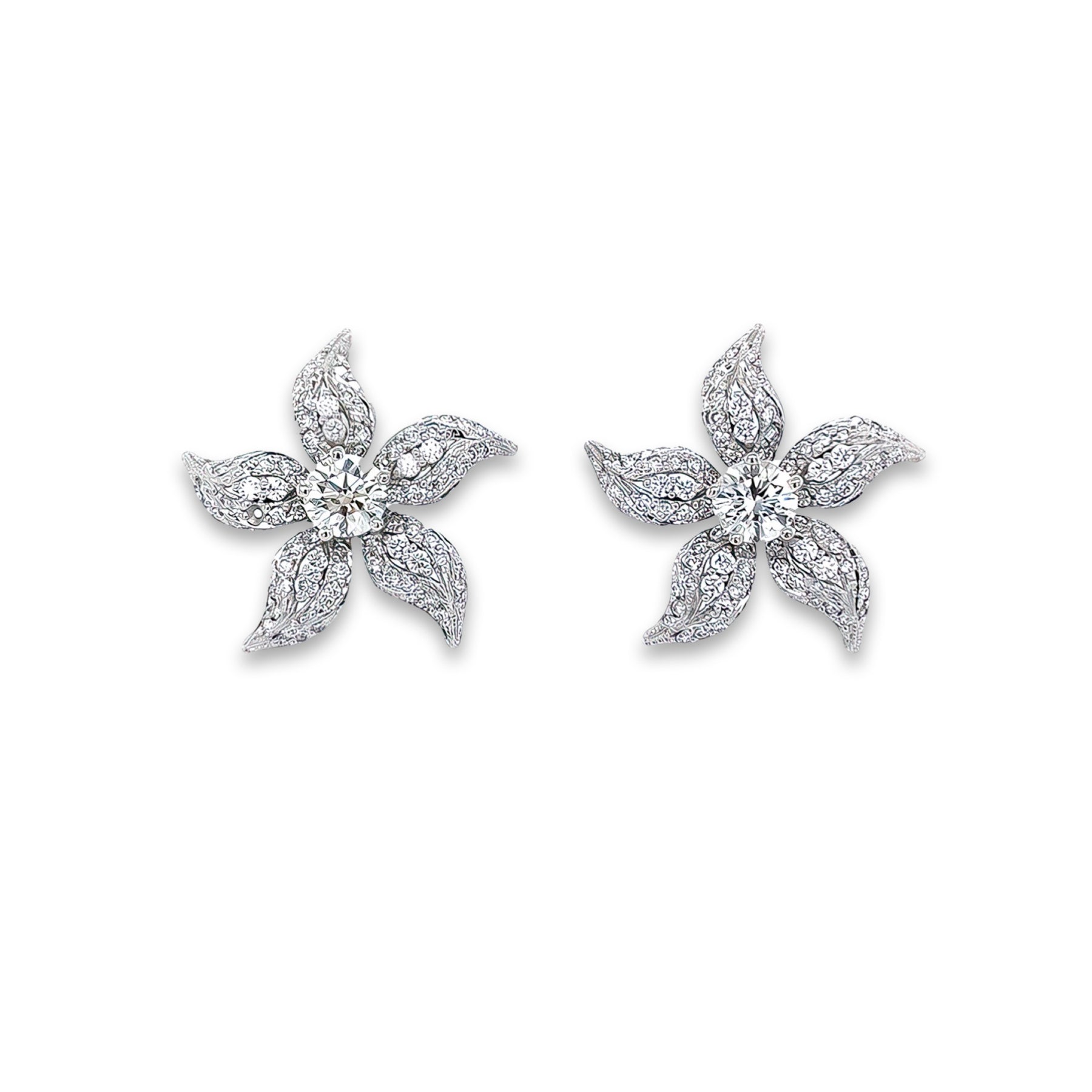 A pair of platinum and diamond flower stud earrings with a floral design.