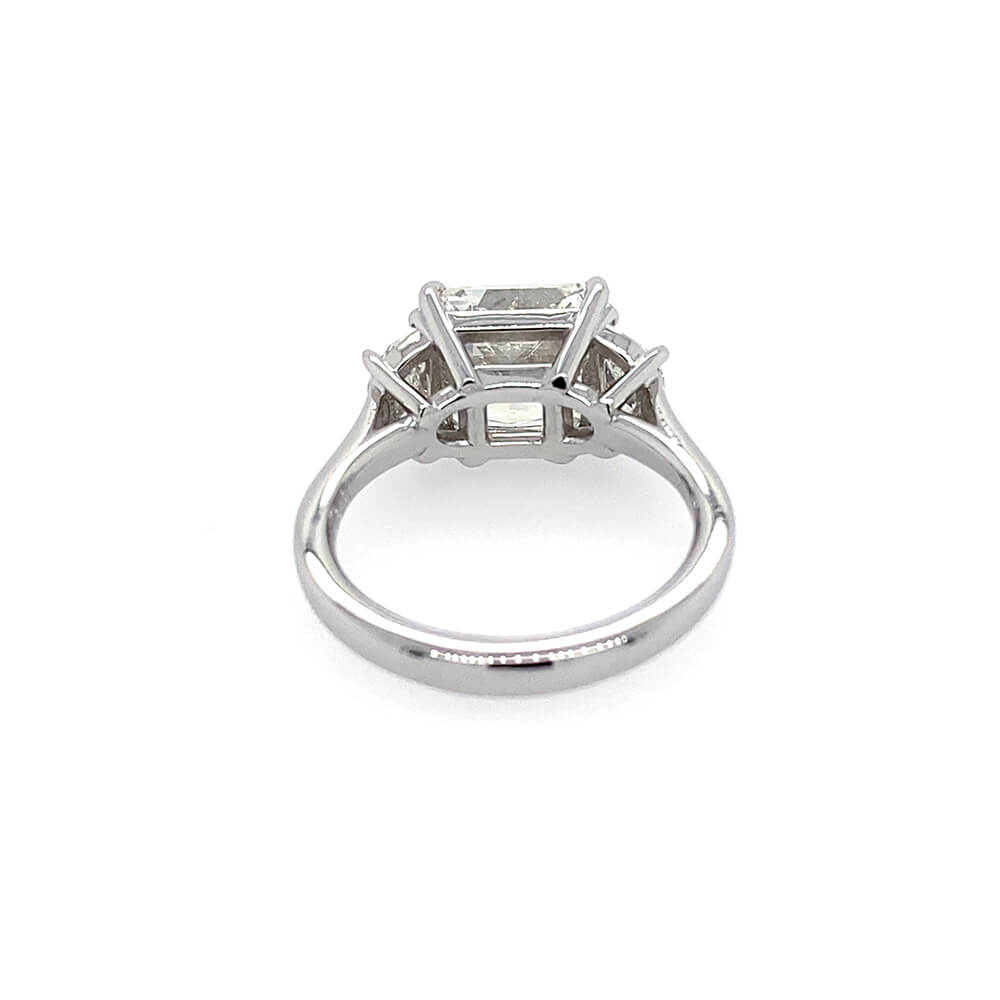 A platinum diamond ring featuring a rectangular east to west center diamond and smaller side diamonds, shown on a plain white background.