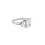 A custom platinum five-stone diamond ring featuring an emerald-cut center stone and baguette-cut side stones, set on a plain white background.