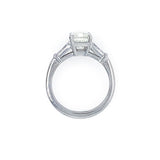 A platinumsolitaire engagement ring featuring an emerald cut center stone in a four-prong setting, with two baguette side stones, shown on a plain white background.