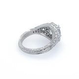 A platinum diamond ring with a textured, filigree band and a cluster of small diamonds on the top, photographed on a clean white background.