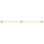 A delicate 18K yellow gold chain bracelet featuring small round bezel-set clear diamonds spaced evenly along the chain, shown against a plain white background.