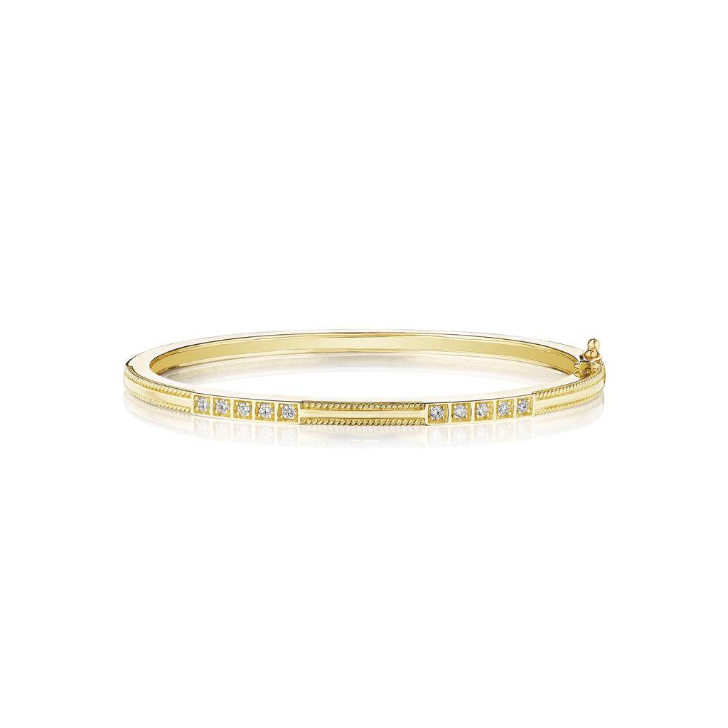 An 18K yellow gold bangle with a diamond box set pattern, designed by Penny Preville
