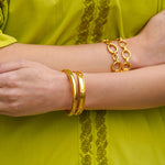 Close-up of woman wearing Elizabeth Locke 19K gold bracelets 