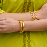 Close-up of woman wearing Elizabeth Locke 19K gold bracelets 