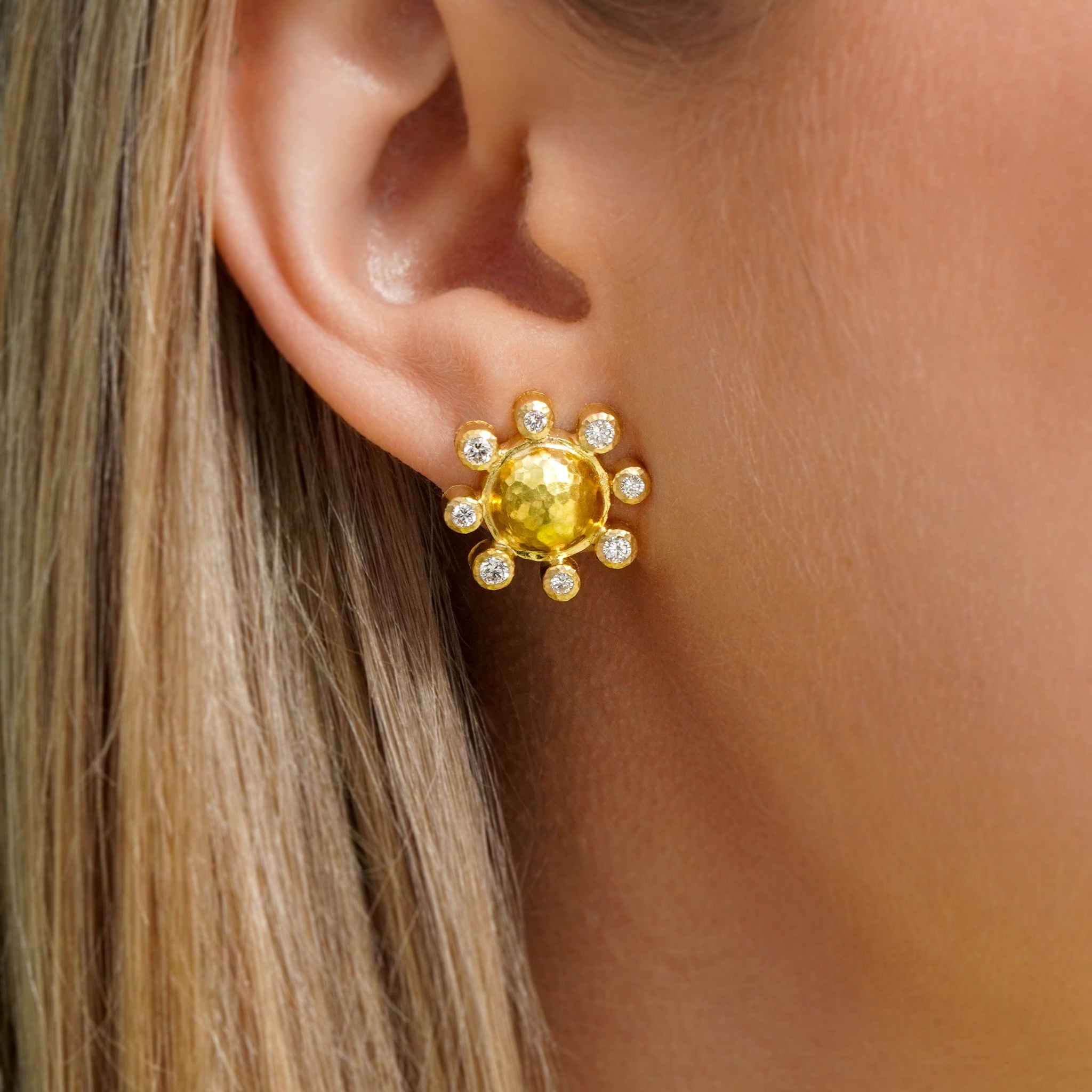Close-up of a woman wearing a 19K yellow gold earring with diamonds 