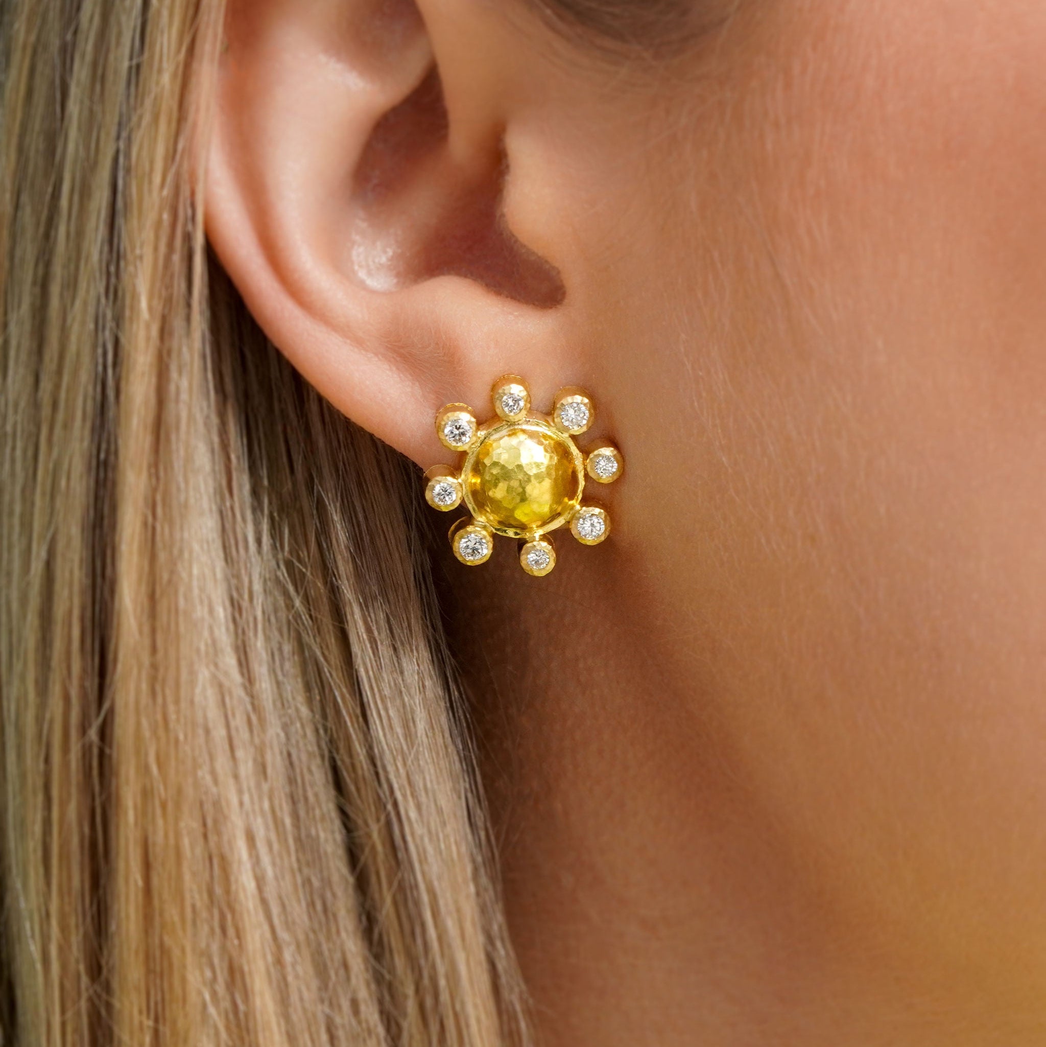 Close-up of a woman wearing a 19K yellow gold earring with diamonds 
