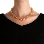 19K Gold link necklace on a woman wearing a black top against a white background