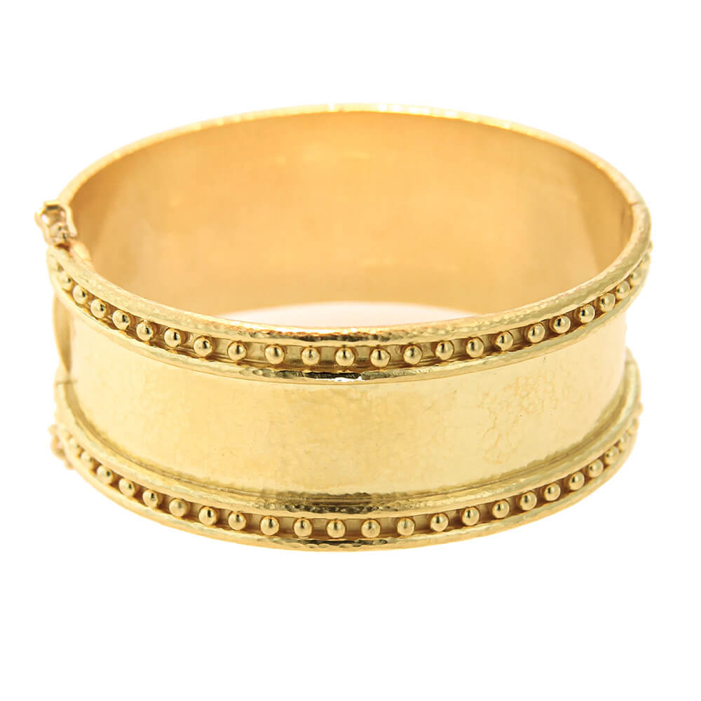 A wide 19k yellow gold cuff bracelet with textured finish and rows of small bead-like details around the edges, shown on a plain white background.