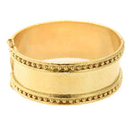 A wide 19k yellow gold cuff bracelet with textured finish and rows of small bead-like details around the edges, shown on a plain white background.