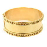 A wide 19k yellow gold cuff bracelet with textured finish and rows of small bead-like details around the edges, shown on a plain white background.