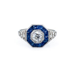 Elegant Estate Platinum ring with Sapphires and a diamond on a white background