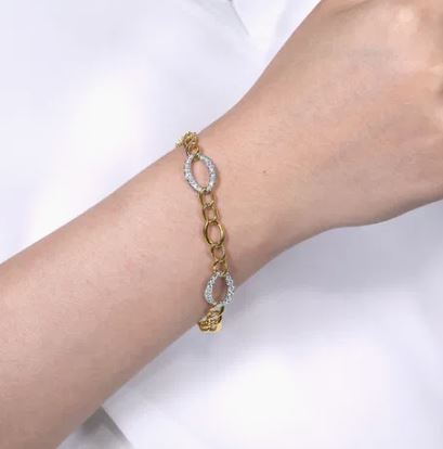 Yellow and White Gold bracelet with diamond accents on a wrist against a white background