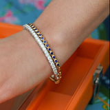 Woman wearing 18K yellow gold sapphire bracelet and diamond bracelet