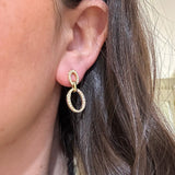 Close up of Gumuchian 18K gold and diamond drop earrings 