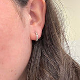 Close-up of an ear wearing Jude Frances silver and gold hoops