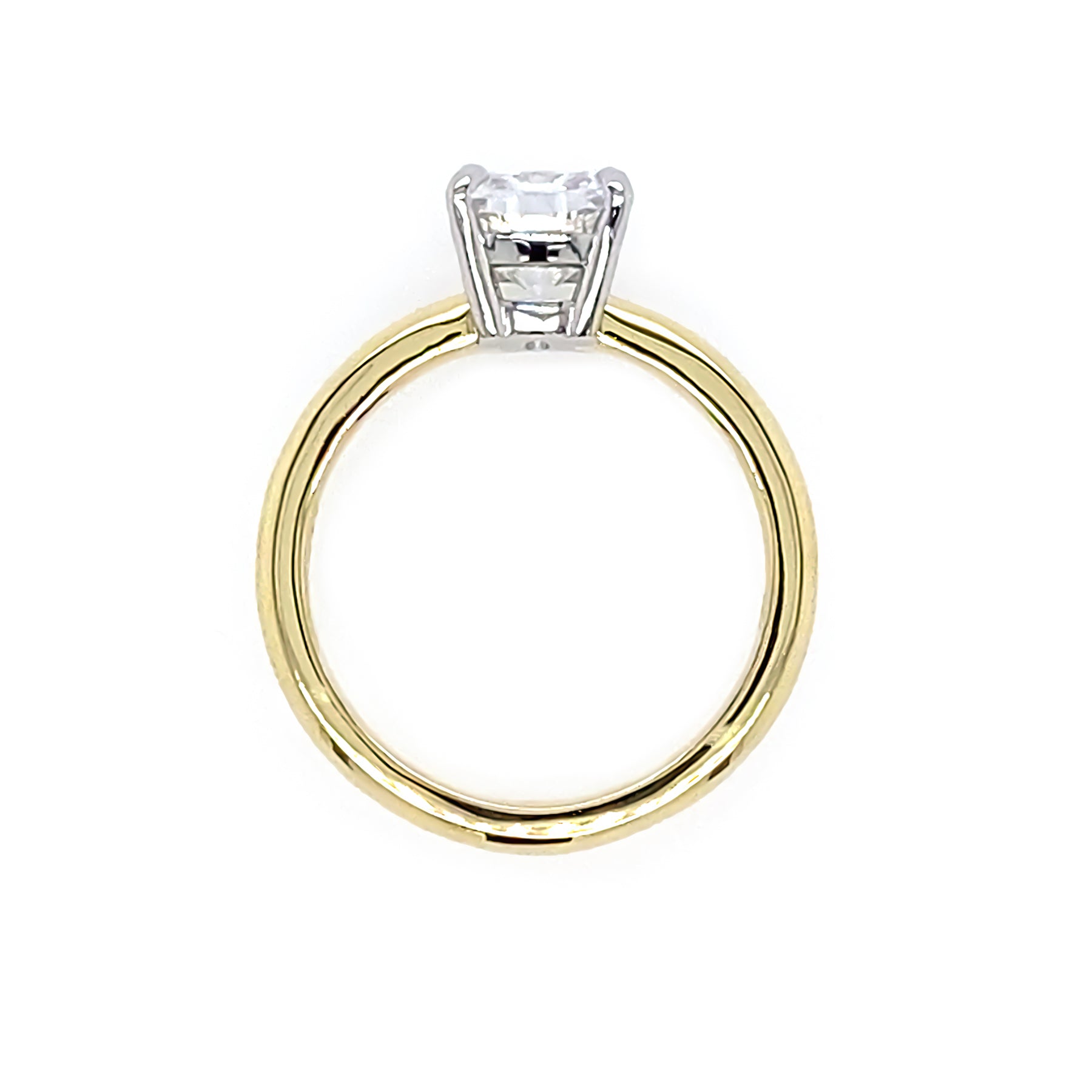 side view of a gold ring with a cushion diamond on a white background