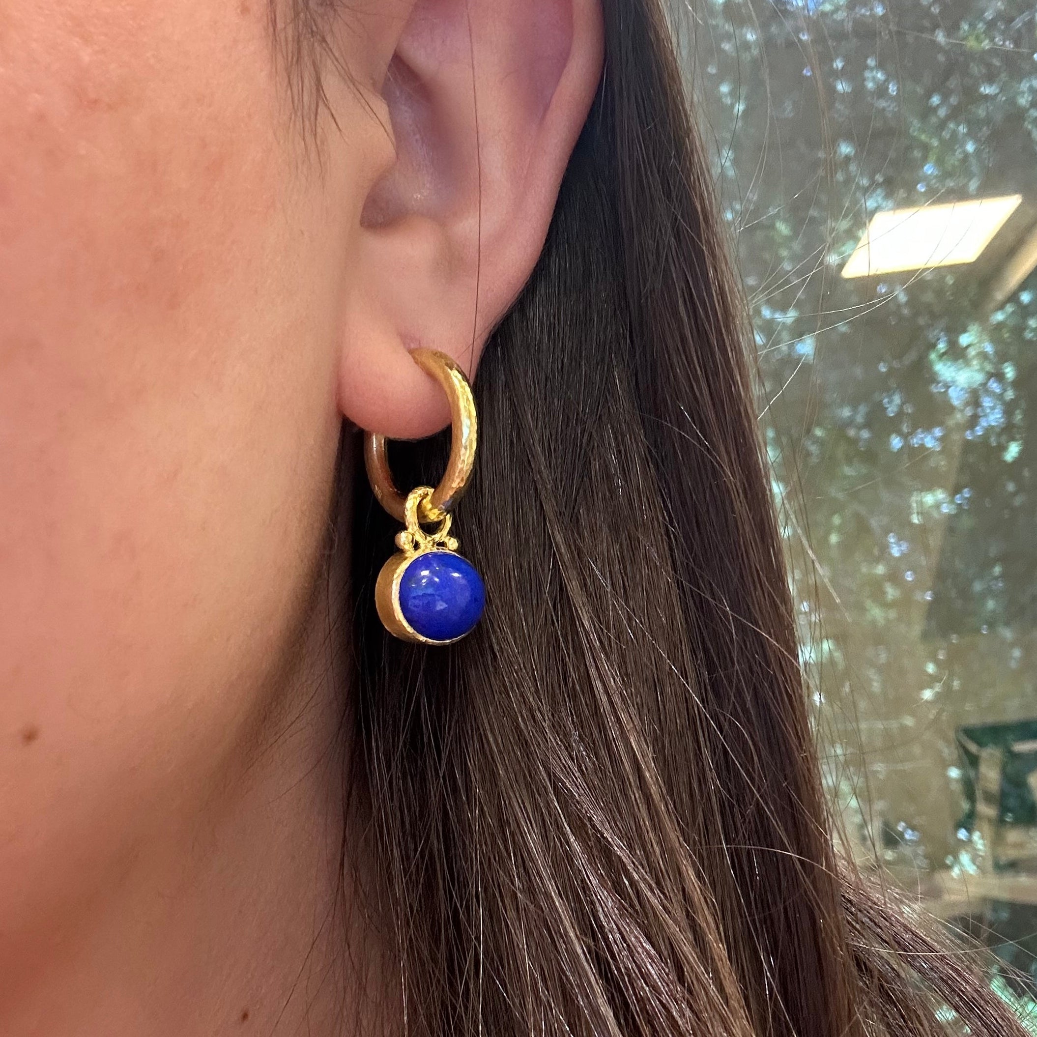 Close-up of an earring with a blue Lapis gemstone 