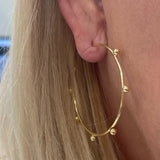 woman wearing 14K gold hoop earrings with gold beads